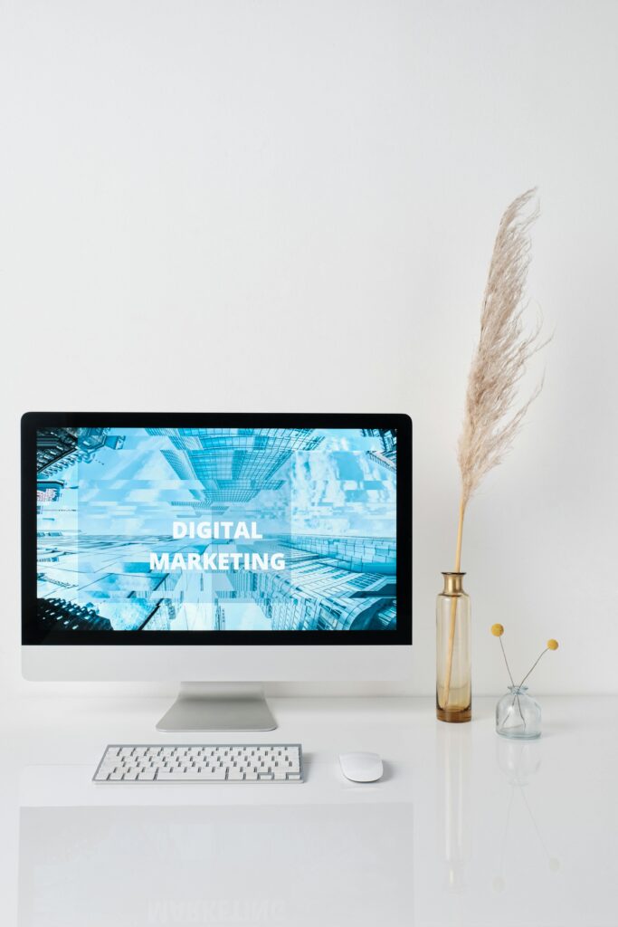 pexels-photo-6483621-6483621 Modern workspace featuring a monitor displaying digital marketing graphics on a minimalist desk.
